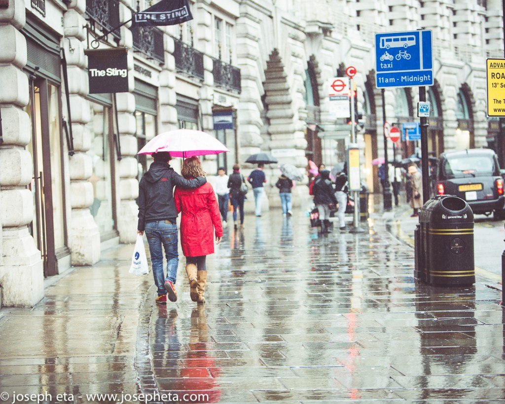 A couple walking down Regents Street in the rain in London