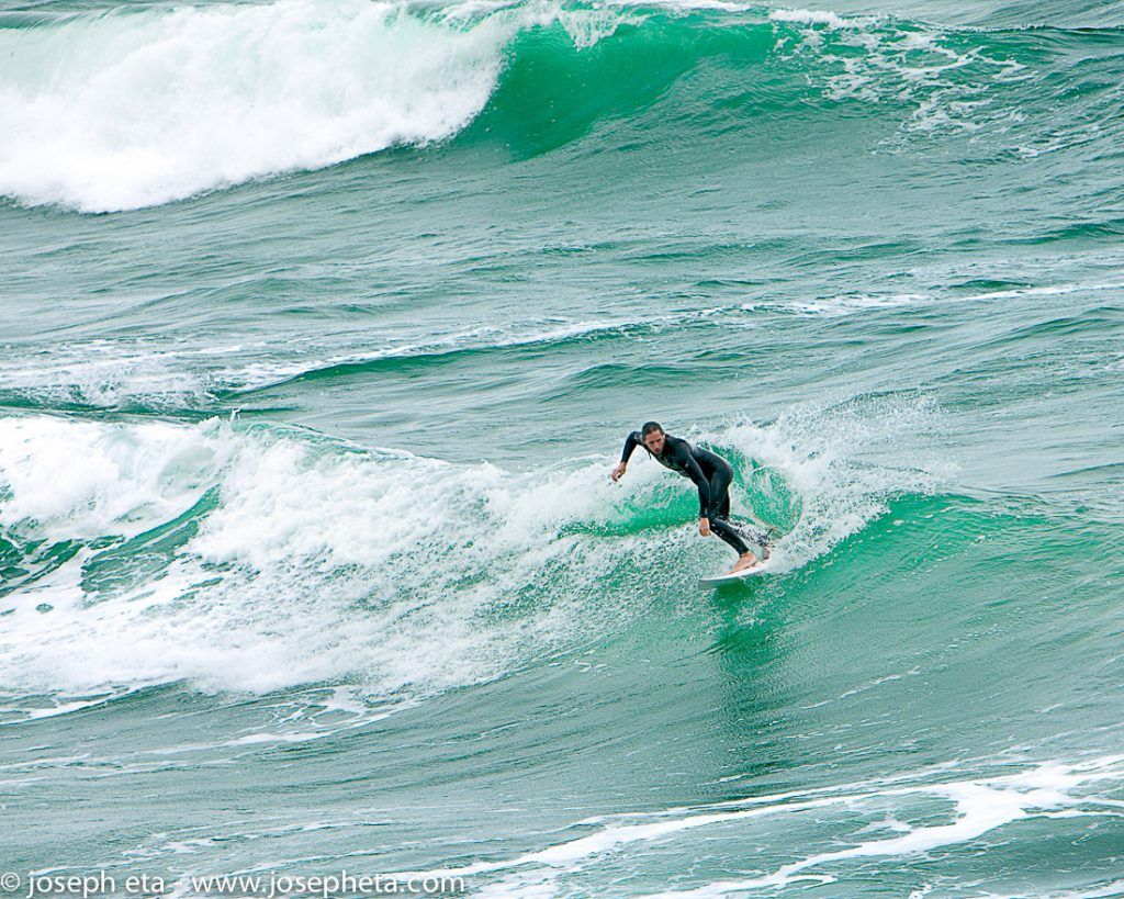 Photo of a surfer negotiating a wave at Fristal beach in Newquay, Cornwall