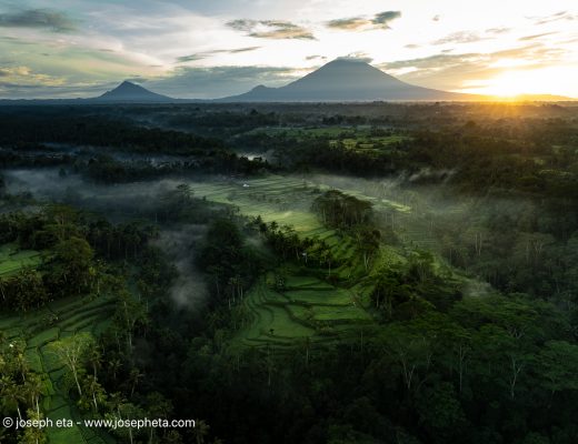 Panoramic sunrise over misty mountains.