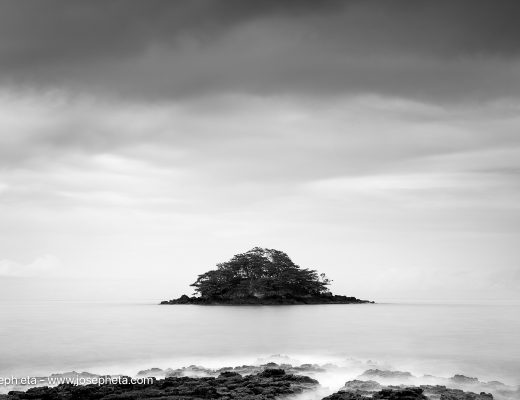 Framed black and white long exposure photography of an island in mist, styled in a dark luxury living room for a visual silence aesthetic.