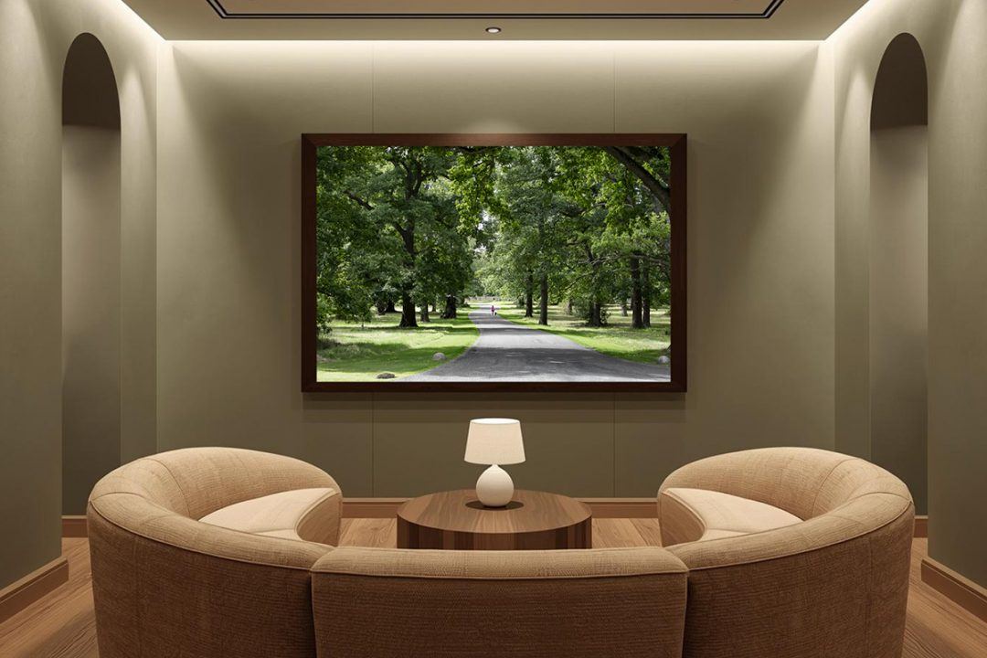Mockup of biophilic fine art photography featuring a paved pathway winding through a serene green park, installed in a secluded, mood-lit waiting room with curved beige seating and architectural arches.