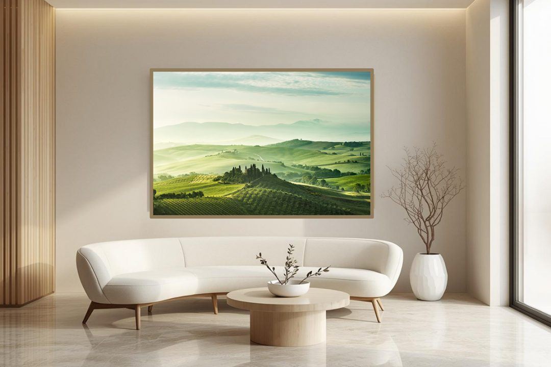 Mockup of biophilic fine art photography featuring rolling green Tuscan hills and morning mist, installed above a curved sofa in a bright, modern clinic waiting room.