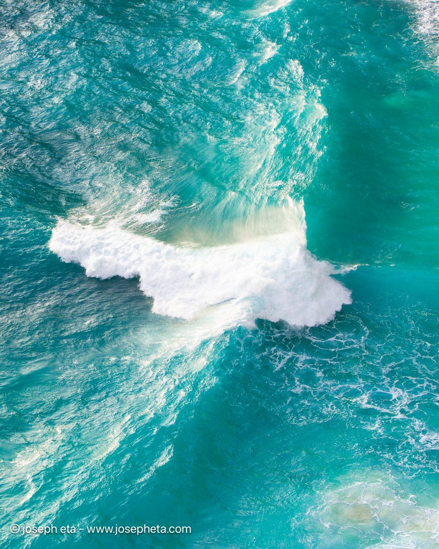 Minimalist marine photography capturing the smooth, rhythmic movement of the deep ocean, creating a striking statement over a dark charcoal accent wall.