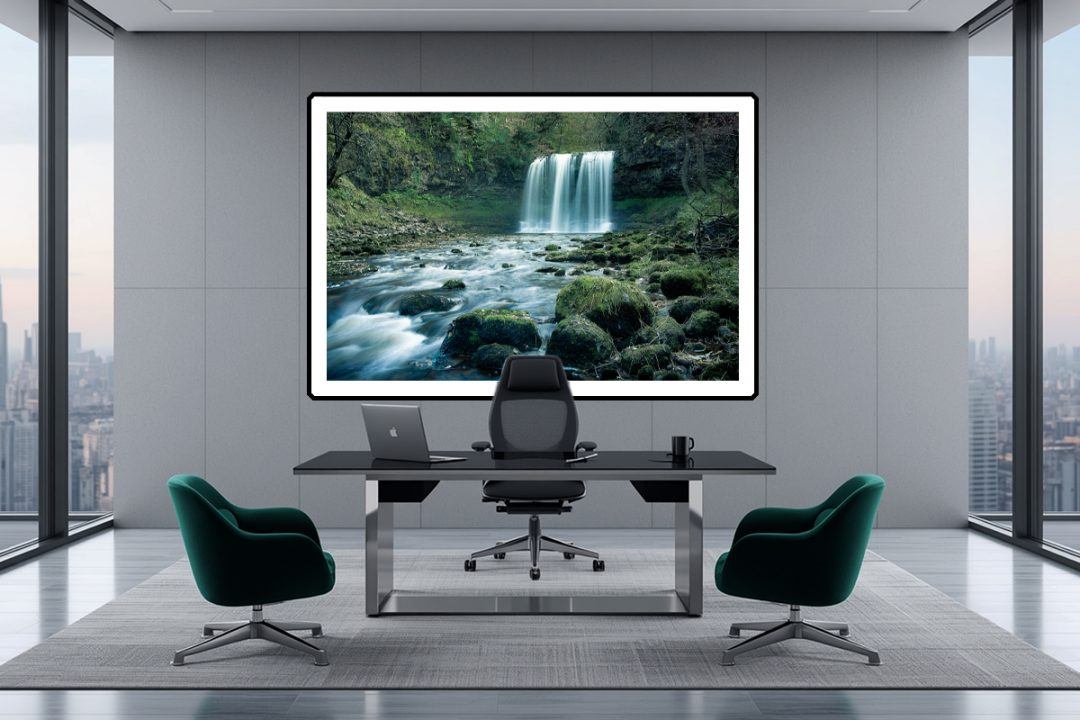 Flow State. Curated for a meditative, highly focused executive workspace. The long-exposure rush of the waterfall dictates a calm visual frequency, while the deep emerald visitor chairs seamlessly pull the organic moss tones straight out of the canvas and into the room.